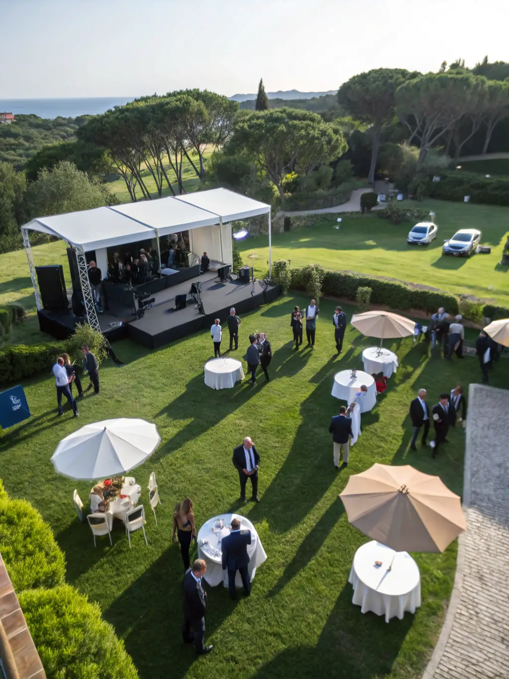 Aerial view of a large corporate event, capturing the scale and atmosphere with a drone. The image should be dynamic and engaging.