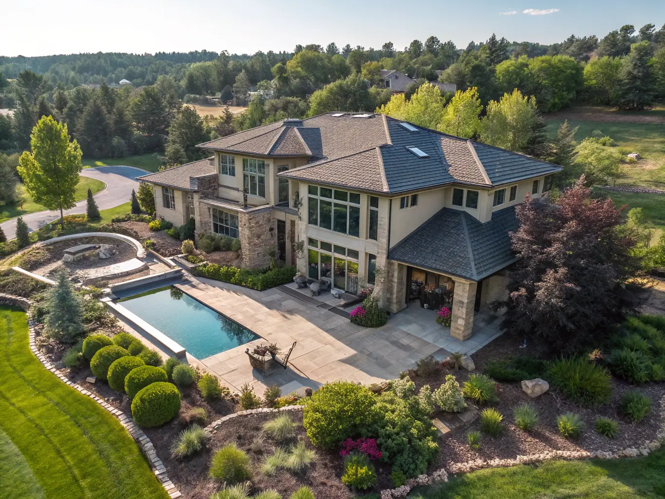 A high-angle shot of a modern luxury home with a drone in the sky, showcasing real estate aerial photography services.